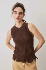 Blusa tejida sin mangas en color marrón chocolate, con textura acanalada, cuello redondo y detalle de flecos en el ruedo.