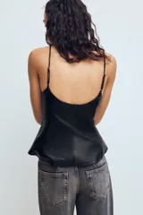 Top de tirantes finos ajustables con escote redondo y diseño peplum en el bajo. Confeccionado en tejido efecto piel con cierre lateral mediante cremallera oculta.