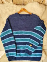 Buzo tejido a mano en lana 100% merino, con diseño de rayas horizontales en tonos azules, celestes y turquesas, cuello redondo y mangas largas.