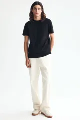 Remera de algodón liviano color negro, con cuello redondo y mangas cortas, de corte entallado.