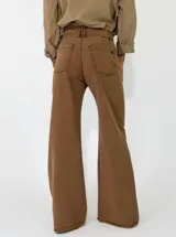 Pantalon de corte recto y tiro medio, confeccionado en gabardina color marrón. Presenta cierre frontal con botón y bolsillos laterales.