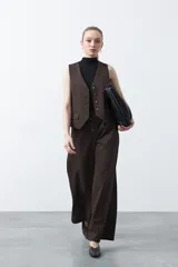 Pantalón wide leg de tiro alto color marrón, con caída fluida y silueta amplia. Presenta cintura alta con botonadura frontal visible.