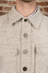 Camisa estilo leñadora marrón con diseño de espiga, cuello clásico, abrochadura frontal a la vista, bolsillos plaqué con tapa en el pecho, mangas largas con puño y botón.
