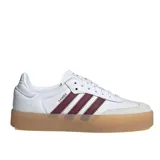 Championes Adidas modelo Sambae, de diseño clásico con capellada de cuero blanco, detalles en color bordó en las icónicas tres tiras y puntera de gamuza en tono claro. Presenta una suela de plataforma de goma en color caramelo.