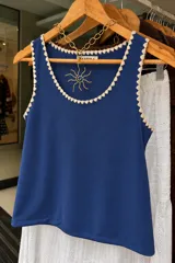 Musculosa de morley verde militar con escote redondo y detalles de bordado artesanal en crochet en los bordes.