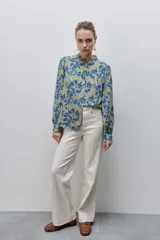 Camisa de calce amplio y fluido de viscosa liviana, con estampado de rayas verticales irregulares en blanco y negro, cuello mao, abotonadura frontal y mangas largas.