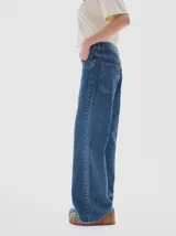 Jean de corte flare con tiro medio, confeccionado en denim de algodón con lavado vintage y desgaste en costuras. Presenta costuras en hilo color oro.