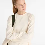 Buzo de algodón color crema, de corte holgado, con cuello redondo y logo bordado en el pecho.