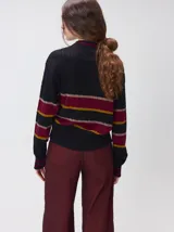 Sweater clásico de punto cable con cuello redondo a la base, mangas largas y fit al cuerpo. De color marrón con franjas horizontales violetas y amarillas, cuenta con el cuello, puños y ruedo acanalados, además de un pequeño logo bordado en el pecho.