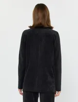 Blazer negro de pana con cuello de solapa, cierre frontal de un botón y bolsillos delanteros.