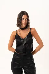 Top de satén negro con escote en V, decorado con detalles de encaje floral en el escote y en el ruedo. Presenta breteles finos ajustables y un corte asimétrico en la parte inferior.