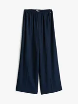 Pantalón largo de viscosa color azul marino, de corte holgado y cintura elástica. Presenta logo metálico de Tommy Hilfiger en la cadera.