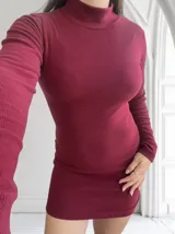 Vestido corto de lanilla color bordó, con cuello alto y mangas largas.