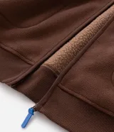 Buzo abierto de hombre confeccionado en tejido sherpa color marrón, con cuello alto, cierre frontal completo y bolsillos laterales. Presenta un diseño de calce regular con acabado interior polar para mayor abrigo.