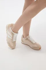 Zapatillas de estilo urbano color marrón con detalles en blanco, confeccionadas en material textil y sintético, con cordones blancos y suela de goma.