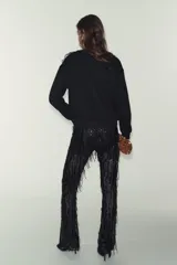 Sudadera de algodón con cuello redondo y manga larga, caracterizada por un detalle de flor con volumen confeccionada en organza sobre el hombro. Presenta terminaciones en rib en puños y ruedo.