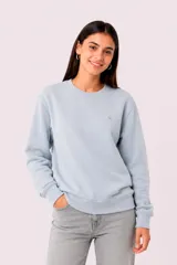 Buzo deportivo gris melange con cuello redondo, mangas largas y puños elásticos acanalados. Cuenta con un pequeño logo bordado en el pecho.