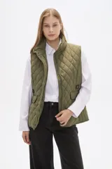 Chaleco acolchado de diseño capitoneado en color verde militar, con cuello alto, cierre frontal con botones a presión y bolsillos laterales con solapa y detalles en contraste.