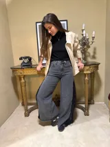 Jean de corte flared confeccionado en denim negro lavado, con aplicación lateral de encaje con flecos y lentejuelas.