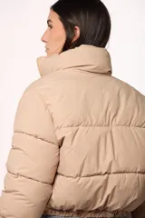 Campera bomber de nylon color negro, con cuello alto, cierre frontal y puños elásticos.