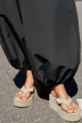 Sandalia de plataforma color negro, con diseño de dedo tipo ojota y suela alta corrida.