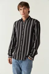 Camisa de mangas largas con estampado a rayas verticales en tonos verde oliva, blanco y azul. Corte regular y logo bordado en el pecho. Confeccionada en viscosa.