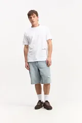 Bermuda de jean de corte baggy, con silueta amplia, largo por debajo de la rodilla y roturas sutiles.