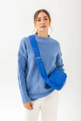 Cartera tipo bandolera acolchada de color verde brillante, con correa ancha y ajustable con hebilla metálica.