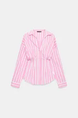 Camisa de popelina con diseño a rayas verticales rosadas y blancas, cuello solapa con escote en V, manga larga y detalle de pliegues marcados en la cintura. Cierre frontal con botones ocultos.