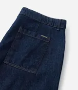 Bermuda tipo jorts de corte amplio y tiro medio, confeccionada en denim de algodón azul oscuro. Presenta diseño de cinco bolsillos, cierre frontal con botón y costuras en tono contrastante.