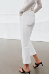 Jeans de tiro medio con corte flare y largo cropped. Presentan diseño de cinco bolsillos, cierre frontal con cremallera y botón, raya planchada en el delantero y bajo desflecado con acabado evasé.
