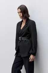 Blazer sastrero negro de silueta recta y calce relajado, con cuello con solapas, hombros levemente estructurados y bolsillos delanteros con vivo.