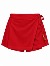 Short pollera de tiro alto símil lino, color rojo, con diseño cruzado tipo falda al frente y lazos laterales decorados con cuentas de madera.