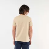 Remera lisa de manga corta en color beige, con cuello redondo y un pequeño bordado en el pecho que representa una taza de café.
