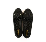 Mocasín de gamuza color negro con detalle de flecos y lazo frontal con herrajes metálicos dorados. Cuenta con interior forrado en cuero y suela de goma flexible.
