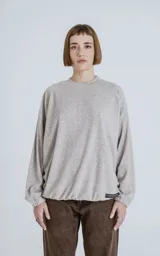 Sweater de tejido jaspeado color beige claro, con cuello redondo, mangas ranglán y elástico ajustable en el bajo.