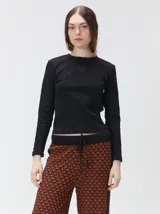 Pantalón de punto jacquard con diseño geométrico texturizado, de corte holgado y pierna ancha. Presenta tiro medio, cintura elástica con cordón ajustable y aberturas laterales en el ruedo.