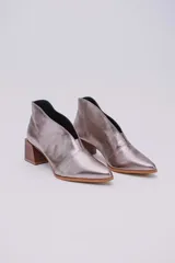 Botines de cuero color beige con diseño de tajo frontal, punta fina y taco cuadrado de madera.