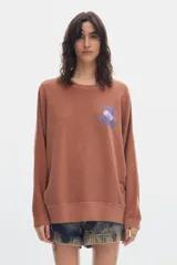 Buzo de felpa sin frisa color terracota con efecto washed, cuello redondo y fit relajado. Presenta un pequeño estampado azul en el pecho.