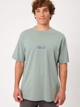 Remera blanca Rusty de corte holgado, con cuello redondo y mangas cortas. Presenta un estampado en la espalda de estilo veraniego con palmeras, una tabla de surf y letras alusivas a la marca.