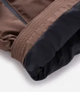 Campera puffer deportiva Get Over, color negro, con diseño sin costuras, cierre frontal por cremallera y capucha con cordón ajustable. Presenta puños elásticos y diseño acolchado.