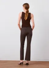 Jeans Sienna de corte recto y tiro medio, en color marrón oscuro, con bolsillos tradicionales y cierre frontal con botón y cremallera.