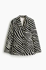 Blazer de botonadura sencilla en sarga de algodón, de ajuste entallado, con solapas de pico, hombreras, bolsillos delanteros con solapa y abertura en los puños.
