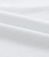 Remera polo blanca de algodón con cuello inglés y cremallera.