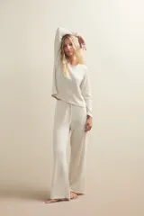 Pantalon de descanso de corte amplio y tiro medio, con cintura elástica y cordón ajustable. Presenta un diseño liso en tono beige jaspeado.
