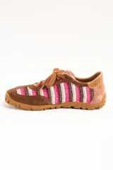 Zapatillas de estilo retro con diseño de rayas en tonos rosa, blanco y marrón. Combinan detalles en gamuza marrón y suela de goma con relieve.