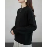 Sweater de punto color crema con diseño de trenzas y rombos, cuello redondo y mangas largas. Presenta un pequeño aplique decorativo en el pecho.