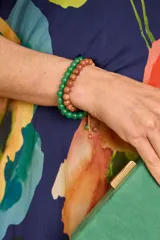 Pulsera de piedras esféricas facetadas en color verde, con cierre ajustable de cordón.