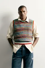 Chaleco de punto tejido en hilatura de algodón con diseño patchwork de patrones jacquard multicolores, cuello redondo y terminaciones en rib.