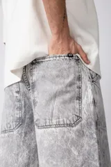 Pantalón de jean con corte baggy y fit oversize, de color gris con efecto lavado ácido. Presenta costuras reforzadas y diseño de pierna ancha.